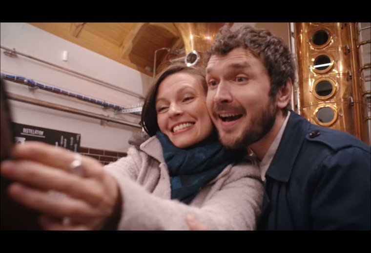 Frau und Mann lächeln in Handy Kamera bei Selfie