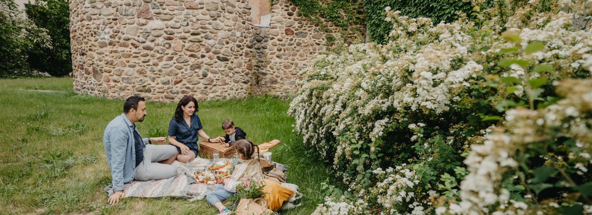 Familie sitzt beim Picknick vor Wallgarten Burg Ruine Calau