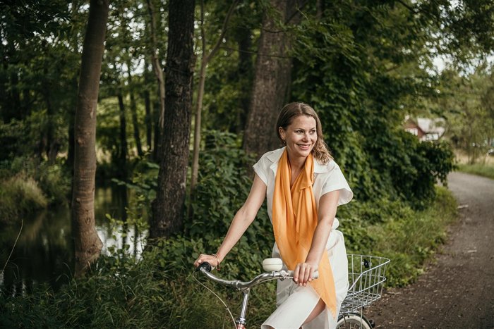 Frau fährt Fahrrad im Spreewald auf Tour am Fließ
