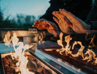 Kaminkahn Nahansicht Hände wärmen sich an Feuer